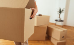 Close up of woman hands carrying box while moving house